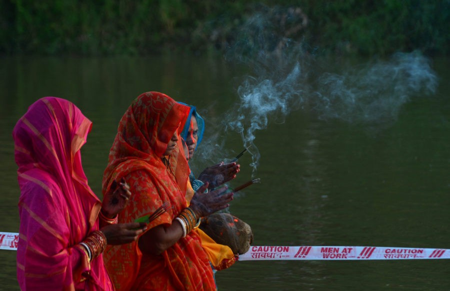 Hindu devotee with incense sticks in their hands offer prayers to Sun God during the Chhath Puja in Dimapur's Dhansiri River on November 19. (Photo by Caisii Mao)